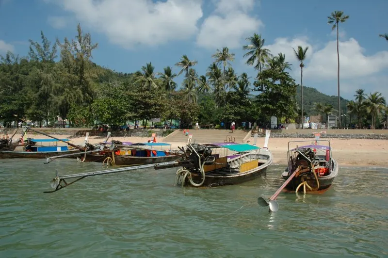 A line of longtail boats pulled up on the shore at Ao Nang, Krabi